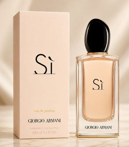 Giorgio Armani Si Eau de Parfum bottle with a black cap next to its pale pink packaging box, set against a warm beige background.